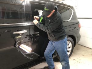 tech performing paintless dent repair